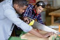 two men in carpentry workshop one using handsaw Royalty Free Stock Photo