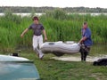 Two men carry an inflatable rubber boat. Russia. Volga river