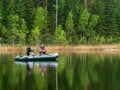 Two men catch fish from an inflatable boat with fishing rods on the lake