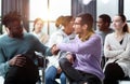 two men communicate while sitting on a chair waiting for a speaker Royalty Free Stock Photo