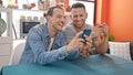 Two men couple drinking coffee using smartphone at dinning room Royalty Free Stock Photo