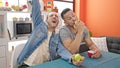 Two men couple eating apple singing song at dinning room Royalty Free Stock Photo