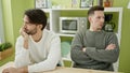 Two men couple with unhappy expression at dinning room Royalty Free Stock Photo