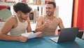 Two men couple using laptop reading document at dinning room Royalty Free Stock Photo