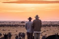 two men in cowboy hats watching a herd of animals. Generative Ai