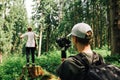 Two men create video content on a hike with a camera on the stabilizer the guy shoots a friend standing on a stump in the