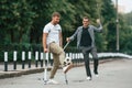 Two men with crutches is outdoors on the road. With a soccer ball Royalty Free Stock Photo