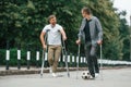 Two men with crutches is outdoors on the road. With a soccer ball Royalty Free Stock Photo