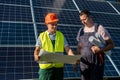 Two men discussing installation plan of new solar station. Green energy concept Royalty Free Stock Photo