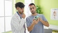 Two men doctor and patient using smartphone at clinic Royalty Free Stock Photo