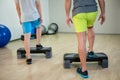 Two men doing step aerobic exercise with dumbbell on stepper Royalty Free Stock Photo