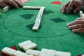 Two men in a domino game ready to put on the next piece