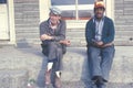 Two men down on their luck sitting on a bench