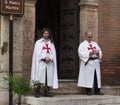 Two men dressed as Templar stand at entrance to church
