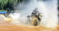 Two Men driving motocross ATV quad through splashing river lake water with high speed. Foy, Foyross Lake, Sudbury Royalty Free Stock Photo