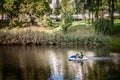 Two men driving a pedalo boat on the pilsetas kanals (the riga city canal) in Bastejkalns Park. It Royalty Free Stock Photo