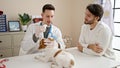 Two men examining dog cleaning ears at veterinary clinic