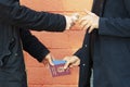 Two men exchange Italian passport and money - concept of illegal immigration, sale of fake passports, sham fake marriage.