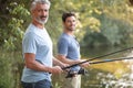 two men fishing from pier on river Royalty Free Stock Photo