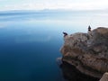 Two men fishing on a rocky promontory at Ancient Heraion, Greece Royalty Free Stock Photo