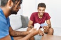 Two men friends playing poker cards sitting on sofa at home Royalty Free Stock Photo