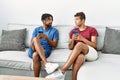 Two men friends using smartphone sitting on sofa at home Royalty Free Stock Photo