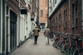 Two men go on empty Amsterdam downtown street with closed bars, restaurants and stores due to outbreak of Coronavirus Royalty Free Stock Photo