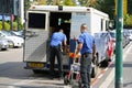 Two men of the guards of the Truck of Brink`s Company put the money bags in the car. guards transporting money. Banking armored