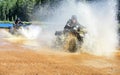 Two Men driving motocross ATV quad through splashing river lake water with high speed. Foy, Foyross Lake, Sudbury Royalty Free Stock Photo