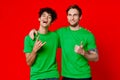 two men hugging in green T-shirts on a red background Royalty Free Stock Photo