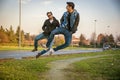 Two Men Leaping in Unison with Hands in Pockets Royalty Free Stock Photo