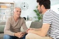 two men in living room talking and smiling Royalty Free Stock Photo