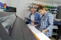 Two men looking down at professional printer