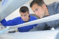 Two men looking into printing machine Royalty Free Stock Photo