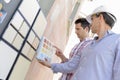 Two men matching colour samples on exterior wall Royalty Free Stock Photo