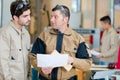 Two men measuring detail and assembling product Royalty Free Stock Photo