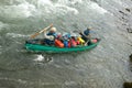 Two men in packed canoe on wild river rapids