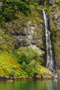 Two men paddling towards a waterfall on a Norwegian Fjord near the Village of Flam,