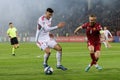 two men playing soccer on a soccer field near a crowd Royalty Free Stock Photo