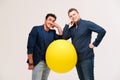 Two men posing with big yellow ball Royalty Free Stock Photo