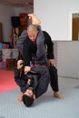 Two men practicing Brazilian Jiu-Jitsu sparring at the Academy.