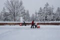 Two men with red snowblowers clearing deep snow from an outdoor skating rink. Ottawa, Canada.