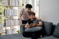 Two Men Relaxing on Sofa with Tablet, Enjoying a Casual Conversation in a Modern Living Room Royalty Free Stock Photo