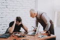 Two Men Repairing Hardware Equipment in Workshop.