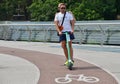 Two men ride on a rental electric scooter on the pedestrian bridge across Saint Volodymyr descent