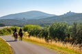 Two men are riding horses in tuscany countryside, Italy, with Capalbio skyline in background Royalty Free Stock Photo