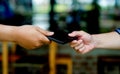 Two men hands and purse hold the same purse. giving gifts to each other Collecting the wallet and returning it to the owner Royalty Free Stock Photo