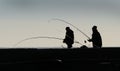 Two men sea fishing from a pier. Royalty Free Stock Photo