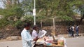 Delhi, India March 8,2016 Two street snack vendors reading newspapers on the road