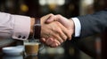 Two professional men shake hand in a cafe